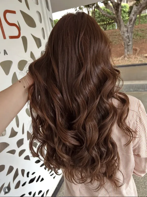 Coloração morena iluminada em cabelo ondulado
